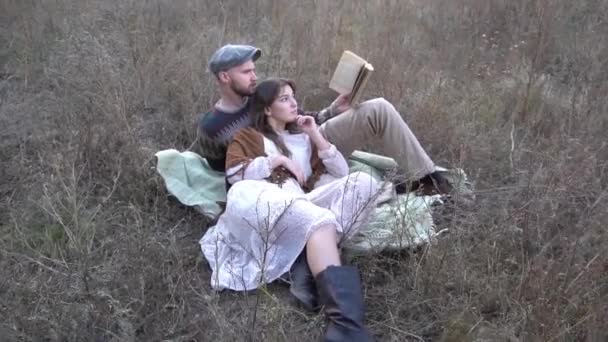 男と女の子本で芝生の上の公園のうそ — ストック動画