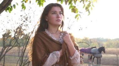 Gün batımında atı olan Yavaş Hareket Kadını, sonbaharda açık havada