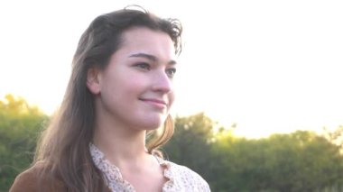 Gün batımında altın tarlada güzel bir kadın.