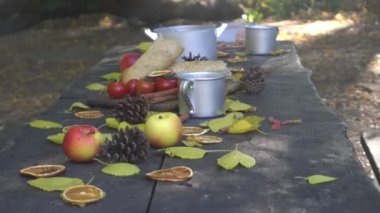 Metal mug in the woods on a table against a background of blurred yellow autumn 