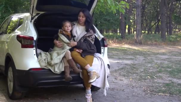 Мать Маленький Ребенок Сидят Багажнике Машины Около Сельской Дороги Осенью — стоковое видео
