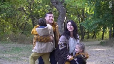 Slow Motion Sonbahar ormanında güzel genç bir aile.