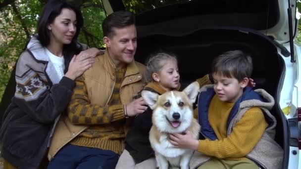 Ευτυχισμένη Οικογένεια Κάθεται Στο Πορτ Μπαγκάζ Του Αυτοκινήτου Φθινόπωρο Φόντο — Αρχείο Βίντεο