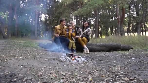 Glückliche Familie Sitzt Auf Bank Und Plaudert Lagerfeuer Wald — Stockvideo