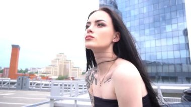 Slow Motion boş bir otoparkta bir arabanın yanında güzel bir genç kız.