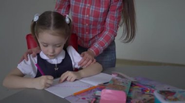 4k Portrait of mother and daughter, mother teaching little girl homework 