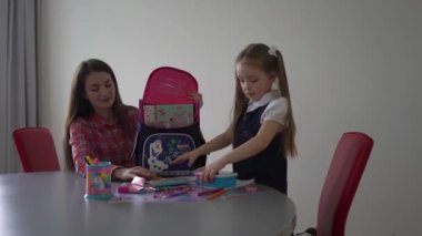 4k Mother helping daughter to get ready for school, helping her with backpack
