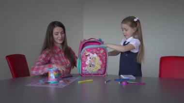 4k mother and daughter packing backpack to school together at home