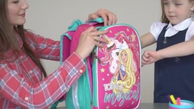 Slow Motion Young mum and daughter packing backpack for the school