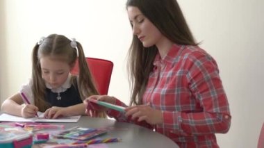 School girl student, child pupil studying at home sitting at desk writing math