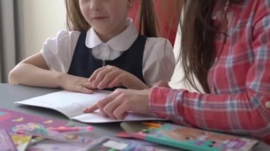 School girl student, child pupil studying at home sitting at desk writing math