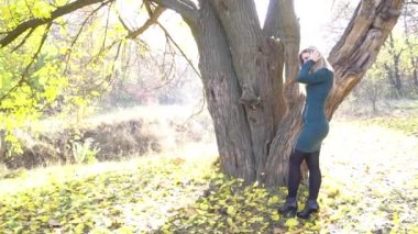 Happy woman having fun time outdoors in the city park in autumn.