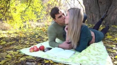 Slow Motion Çifti aşık Sonbahar yaprakları üzerinde parkta oturuyor