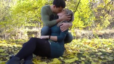 Sonbaharda parkta büyük bir ağacın altında romantik bir çift.