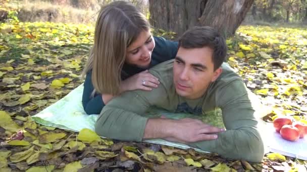 秋の公園で幸せな笑顔のカップルは木の下でリラックス — ストック動画