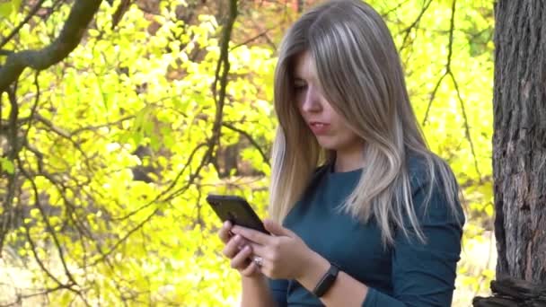 Happy Woman Using Smartphone Autumnal Foliage Autumn Park — Stockvideo