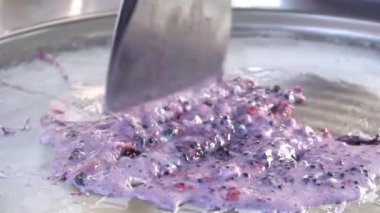 Yetenekli adam dondurucu bir tavada böğürtlen doğrayıp kremayla karıştırıyor..