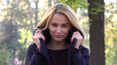 Slow Motion Cheerful woman portrait with autumn maple leaves in the park