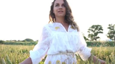 Slow Motion Attractive woman on the background fields of wheat