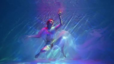 Slow Motion Girl swims underwater with a cloth.