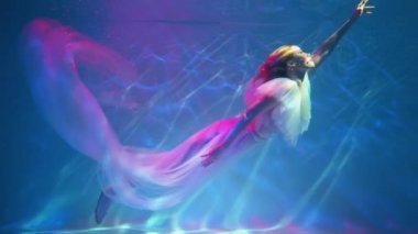 Slow Motion A girl in a white dress posing underwater