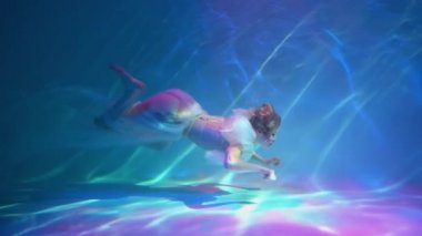 Slow Motion The girl in a beautiful dress under water.