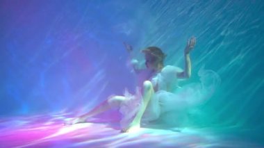 Slow Motion beautiful girl in a dress swims under water. amazing Underwater