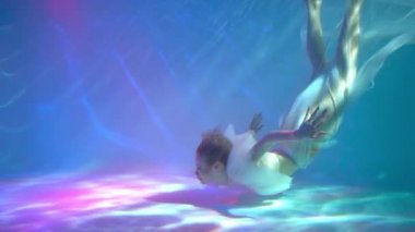 Slow Motion Underwater woman portrait in swimming pool.