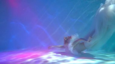 Slow Motion a girl in a swimsuit in the pool under water