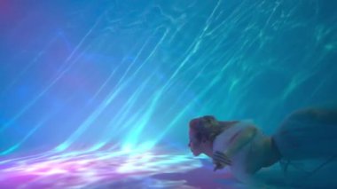 Hot Slim Woman Posing Under water in beautiful clothes alone in the deep