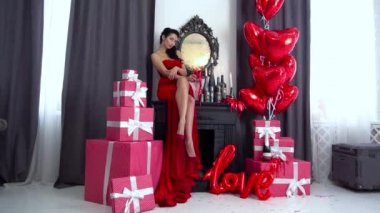Slow Motion Girl Moda modeli balonlarla ve hediye kutularıyla poz veriyor.