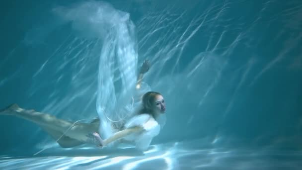 身穿蓝色衣服的漂亮姑娘在水里或海里游泳 — 图库视频影像
