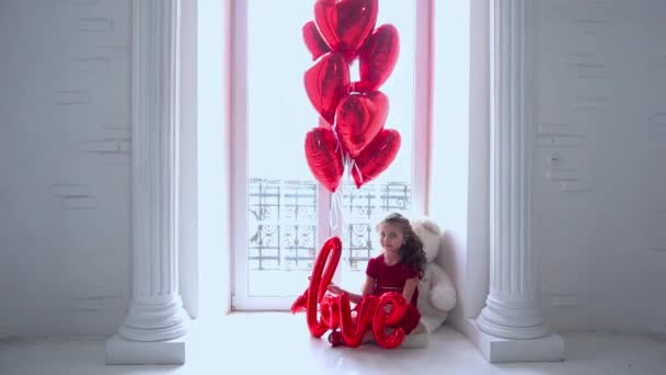 Happy Girl Holding Foil Balloon Letters Indoor Studio Shot – stockvideo