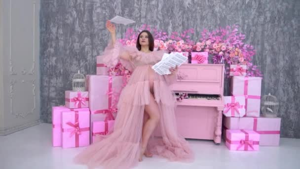 Zwangere Vrouw Een Roze Jurk Nabij Piano — Stockvideo