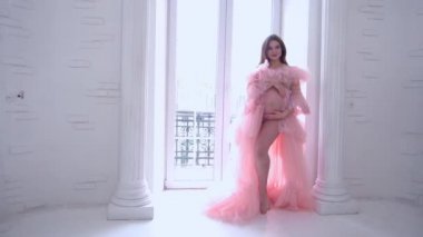 Slow Motion attractive pregnant woman in beautiful pink dress