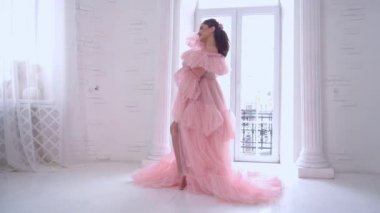 Slow Motion pregnant young girl is wearing luxury pink lingerie dress at home