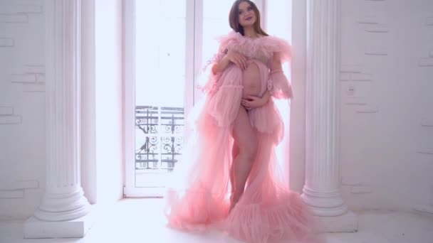 Slow Motion Zwangere Vrouw Roze Jurk Een Witte Kamer — Stockvideo