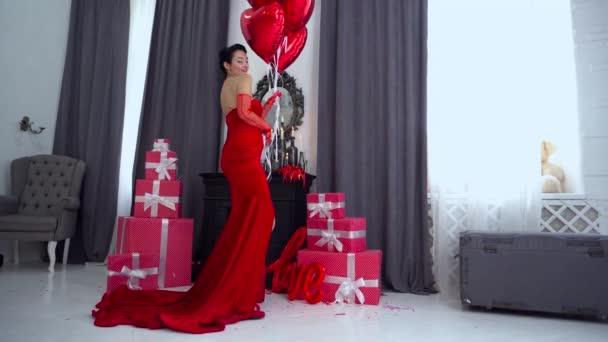 Schöne Frau Roten Abendkleid Posiert Über Roten Großen Herzförmigen Luftballons — Stockvideo