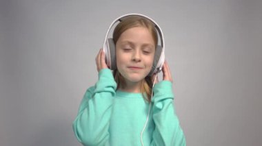 4k Emotional blonde little kid girl listen music in stereo headphones