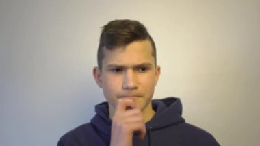 4k Young man with peaceful face thinking over plans for future holding his chin