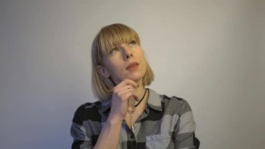 4k Curious blond woman thinking to make a choice 