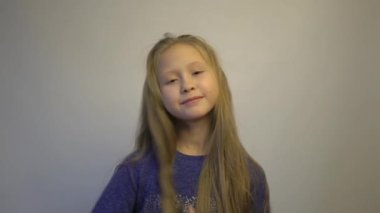 4k A little girl pulls her hair in different directions.