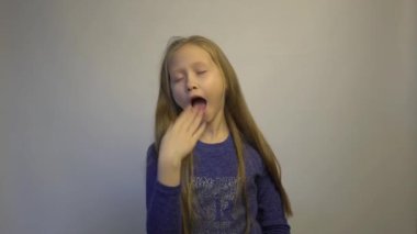 4k Young blonde girl bored yawning tired covering mouth with hand