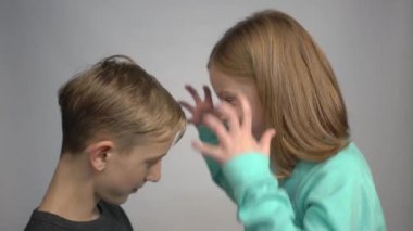 4k little girl screams on boy, hides his face with hands