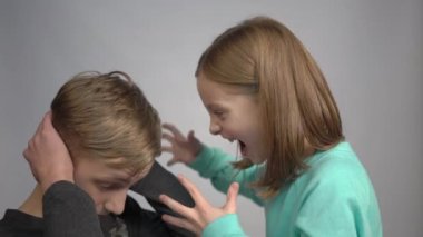 4k The girl screams at the boy. The boy clutches his head and grit