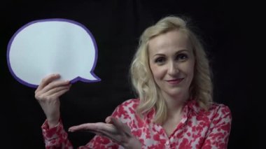 4k Cheerful woman pointing at empty speech bubble in studio
