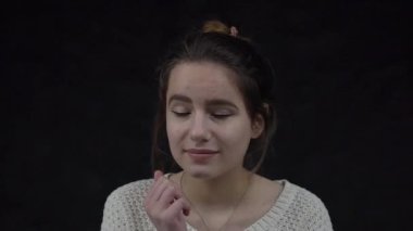 Slow Motion girl thinking and looking up over black background
