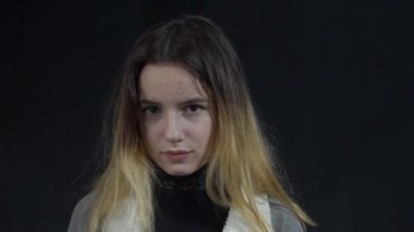 Portrait of girl showing stupid gesture with finger near head, out of mind