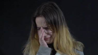 Crying teen girl covers her mouth with her hands