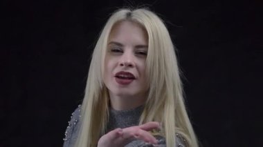 Closeup attractive blond woman looking at camera with toothy smile, flirting